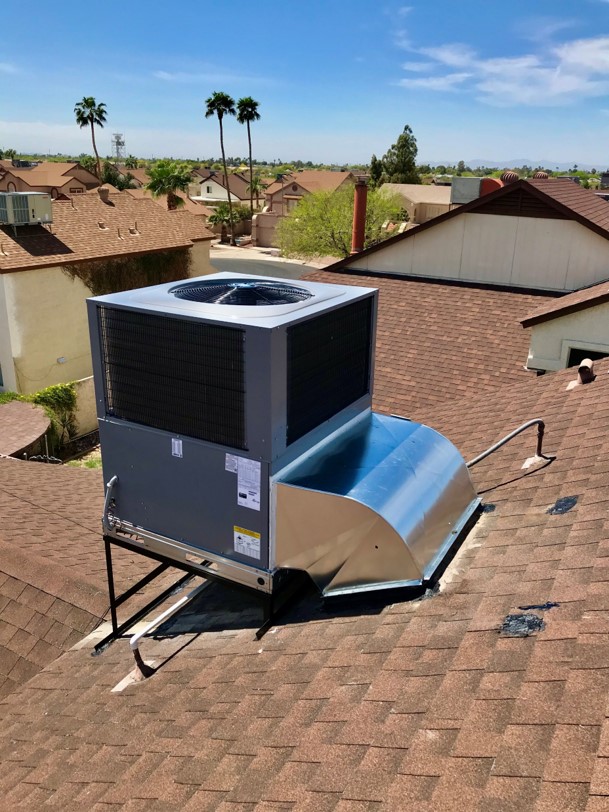 Newly installed rooftop package AC unit with metal ductwork transition on a Phoenix-area roof