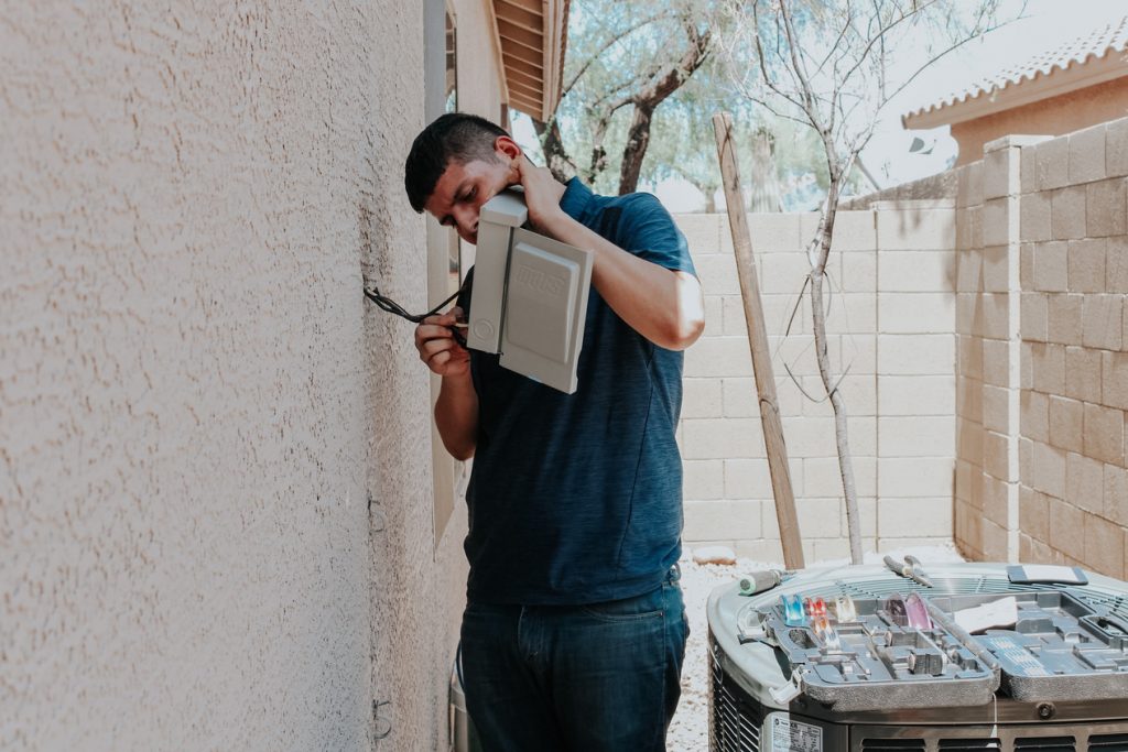 Legendary Energy technician checking wiring on an exterior wall