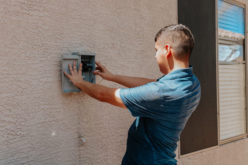 Legendary Energy technician wiring an outdoor electrical disconnect for a heat pump