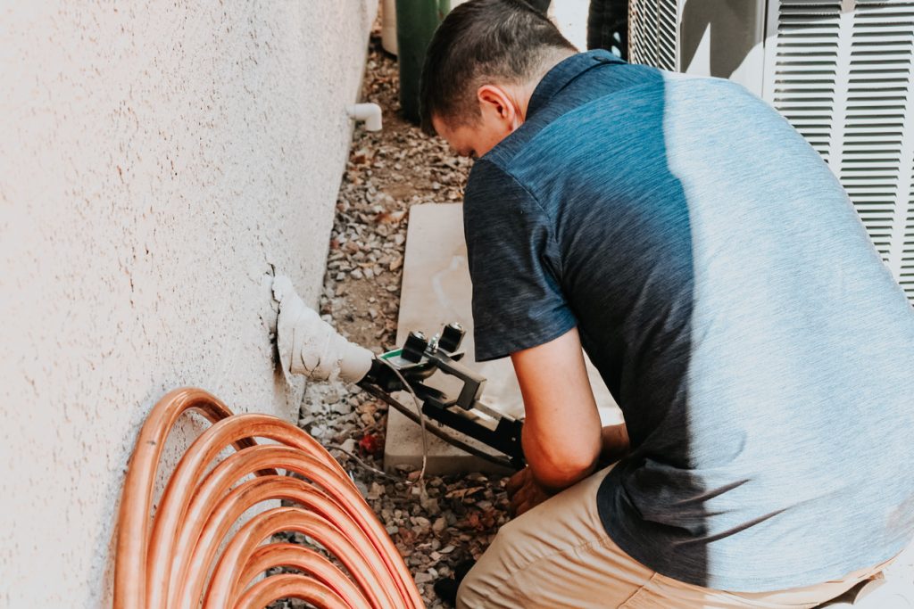 Legendary Energy technician checking connections at an outdoor unit