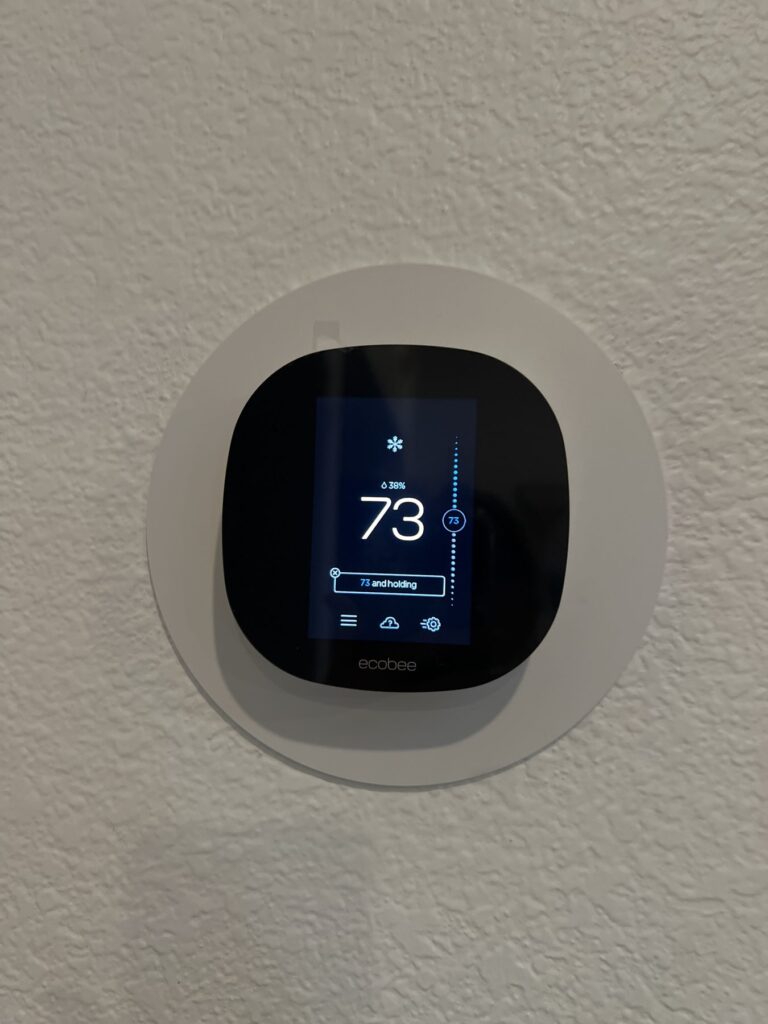 Ecobee smart thermostat installed on a living room wall