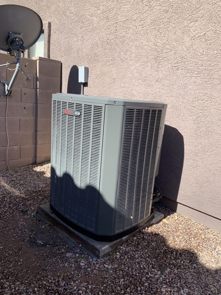 New AC condenser installed in a gravel side yard