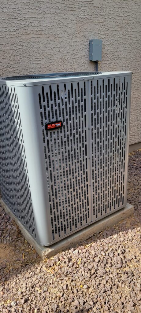 New AC condenser unit on a pad beside a wall