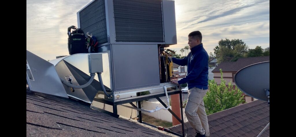 Legendary Energy technician repairing a rooftop package AC unit