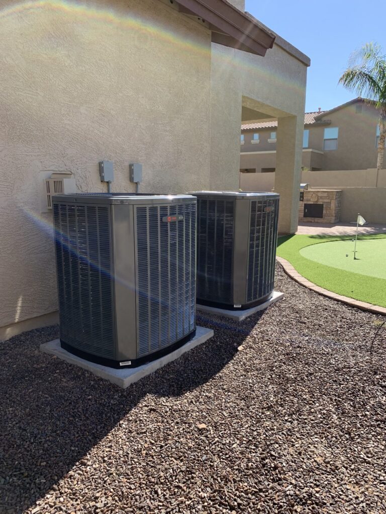 Two new AC condensers installed side by side at a desert home